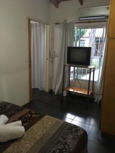 Zimmer mit TV und Bett in der Unterkunft Departamento Belgrano in San Pedro