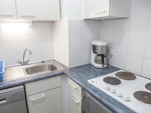 une cuisine blanche avec un évier et une cuisinière dans l'établissement Studio Le Nadir-3 by Interhome, à Fréjus