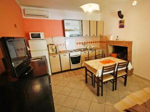 a kitchen with a table and a tv in it at Apartment Dijana-1 by Interhome in Prigradica +10 photos