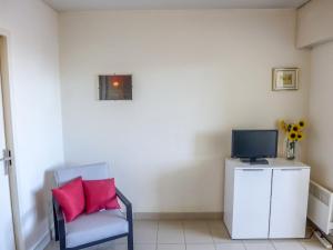 une chaise avec deux coussins roses assis dans une pièce dans l'établissement Studio Le Nadir-3 by Interhome, à Fréjus 17 autres photos