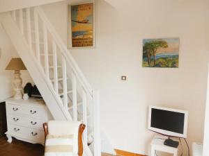 Una sala de estar con una escalera y un televisor. en Holiday Home Domaine des Vignes-4 by Interhome, en Cogolin