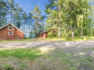 una imagen de una cabaña de madera y una casa en Holiday Home Tallukka by Interhome, en Pertunmaa