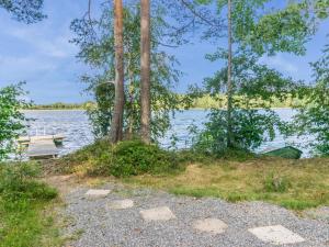 una mesa de picnic y un banco junto a un lago en Holiday Home Tallukka by Interhome, en Pertunmaa