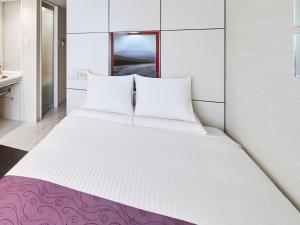 a large white bed with two pillows in a room at HOTEL MYSTAYS Shimizu in Shizuoka