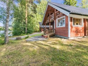 una cabaña de madera en el bosque con un patio en Holiday Home Tallukka by Interhome, en Pertunmaa