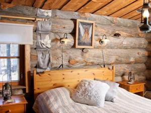 um quarto com uma cama num chalé de madeira em Holiday Home Alppimaja by Interhome em Pätiälä