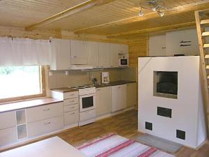 een keuken met witte kasten en een witte koelkast bij Holiday Home Välitalo by Interhome in Inkee
