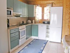 LahdenperäにあるHoliday Home Rusakko by Interhomeのキッチン(緑のキャビネット、白い冷蔵庫付)