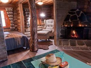 a living room with a fireplace in a log cabin at Holiday Home Peltotupa by Interhome in Pätiälä