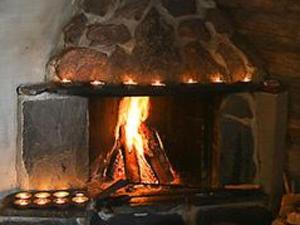 un horno de ladrillo con un fuego dentro de él en Holiday Home Divaanikivi by Interhome, en Pätiälä