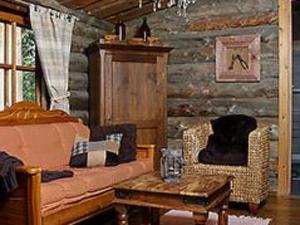 ein Wohnzimmer mit einem Sofa und einem Tisch in der Unterkunft Holiday Home Metsäpirtti by Interhome in Pätiälä