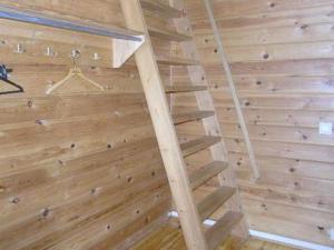 a wooden staircase in a room with a wooden wall at Holiday Home Riitula by Interhome in Jokijärvi
