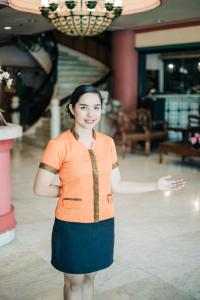 Eine Frau mit orangefarbenem Hemd und blauem Rock. in der Unterkunft La Fiesta Hotel in Iloilo City