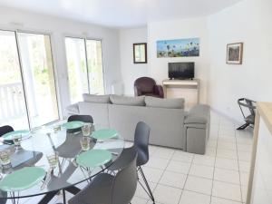 a living room with a couch and a table and chairs at Holiday Home Eden Parc in Lacanau-Océan