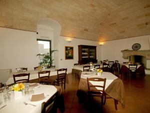 a dining room with tables and chairs and a fireplace at Masseria La Porticella in Avetrana