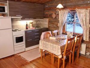 a kitchen with a table and chairs and a kitchen with a stove at Holiday Home Kopinkallio 1 by Interhome in Vääksy