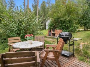 un patio con tavolo, sedie e griglia di Holiday Home Länsipirtti by Interhome a Niskamäki