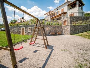 a wooden swing set in front of a house at Villa Marone by Interhome in Dobreć