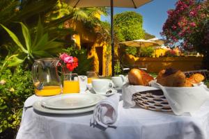 einen Tisch mit einem Korb Brot und Orangensaft in der Unterkunft Family hotel Al- Ana Marbella in Estepona