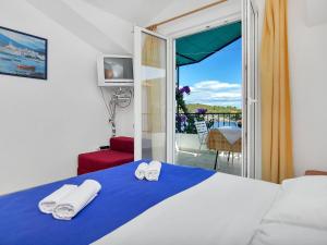 a bedroom with a bed with towels and a balcony at Apartment Rubin-11 by Interhome in Selca kod Bogomolja
