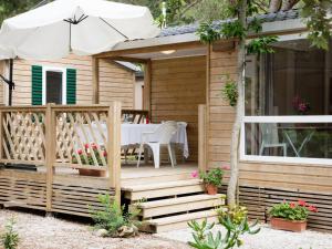 una cabina di legno con tavolo e ombrellone di Holiday Home Gineprino-10 by Interhome a Marina di Bibbona
