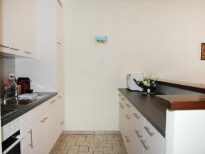 a kitchen with white cabinets and a black counter top at Apartment Sabrina by Interhome in Ascona