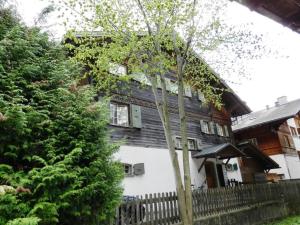 an old house with a fence and a tree at Apartment Studio Oehrli by Interhome in Gstaad