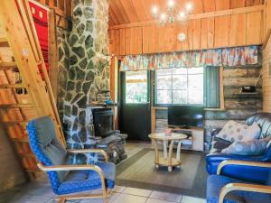 a living room with two chairs and a fireplace at Holiday Home Kantapää d2 by Interhome in Luosto