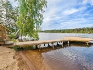 a wooden dock on a lake with a tree at Holiday Home Tähtiranta by Interhome in Valkeala