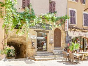 a building with a table and chairs in front of it at Studio Village de Bormes les Mimosas by Interhome in Bormes-les-Mimosas
