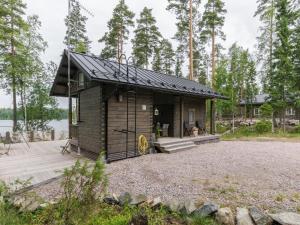 a small wooden cabin with a porch and a deck at Holiday Home Apilan rauha by Interhome in Kerttee