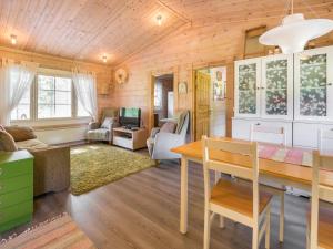 ein Wohnzimmer mit Holzwänden und einem Holztisch in der Unterkunft Holiday Home Isoniemi by Interhome in Suinula