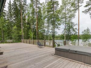 a wooden deck with a bench on the water at Holiday Home Apilan rauha by Interhome in Kerttee