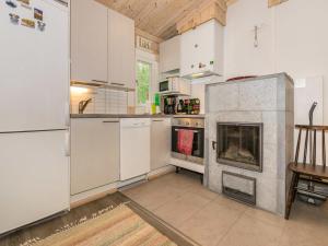 a kitchen with white cabinets and a fireplace at Holiday Home Isoniemi by Interhome in Suinula