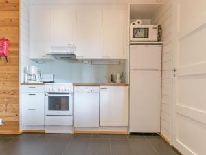 a kitchen with white appliances and white cabinets at Holiday Home Ameno 2 by Interhome in Jämsä