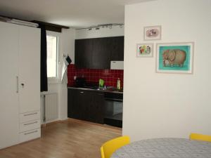 a kitchen with a table and a kitchen with red tiles at Apartment Sörenweg 5 by Interhome in Engelberg