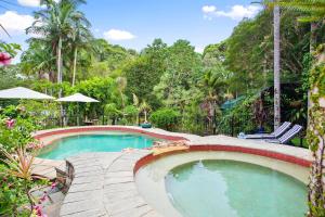 a swimming pool in a resort with chairs and trees at Noosa Valley Manor B&B in Doonan