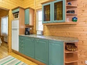 uma cozinha com armários azuis e um frigorífico em Holiday Home Lauhanlinna by Interhome em Isojoki