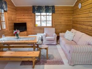 uma sala de estar com um sofá e uma mesa em Holiday Home Rukantaika 1a by Interhome em Virkkula