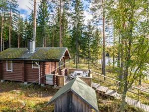 uma cabana na floresta com um alpendre e um deque em Holiday Home Kannonniemi by Interhome em Majavesi