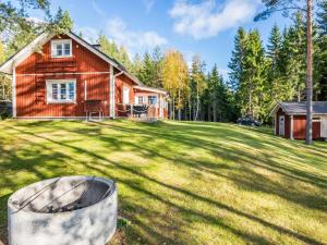 Holiday Home Kannonniemi by Interhome في Majavesi: منزل خشبي مع حفرة نار في الفناء