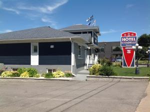 a hotel sign in front of a house with a hotel sign at Hotel Citadelle in Quebec City