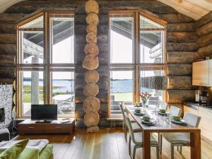 ein Esszimmer mit einem Tisch und einigen Fenstern in der Unterkunft Holiday Home Villa pärla by Interhome in Myllykangas