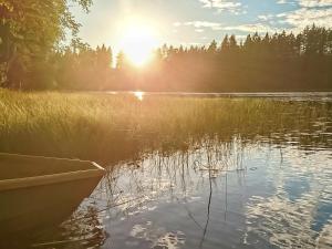 ein Boot auf einem See mit Sonnenuntergang in der Unterkunft Holiday Home Virransivu by Interhome in Kaipiainen