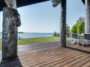 eine Holzterrasse mit Blick auf das Wasser in der Unterkunft Holiday Home Villa pärla by Interhome in Myllykangas