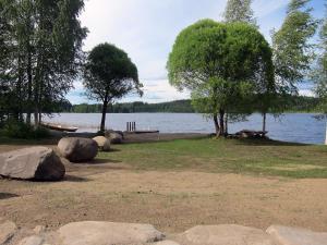 un parque con un lago y árboles y rocas en Holiday Home Kiviniemi by Interhome, en Tohmajärvi