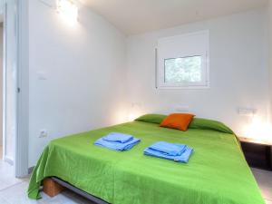 a bedroom with a green bed with two towels on it at Apartment Matthias-2 by Interhome in Llança
