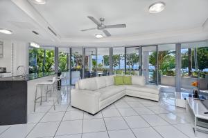a living room with a white couch and a kitchen at Vision Apartments in Cairns