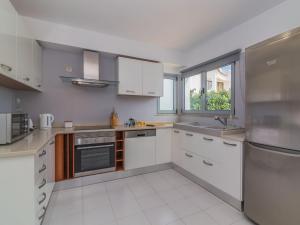 a kitchen with white cabinets and a large window at Villa Arribas Villa by Interhome in Patroves