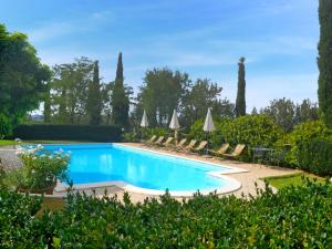 een zwembad in een tuin met stoelen en bomen bij Holiday Home Montecucco Winery by Interhome in Montenero